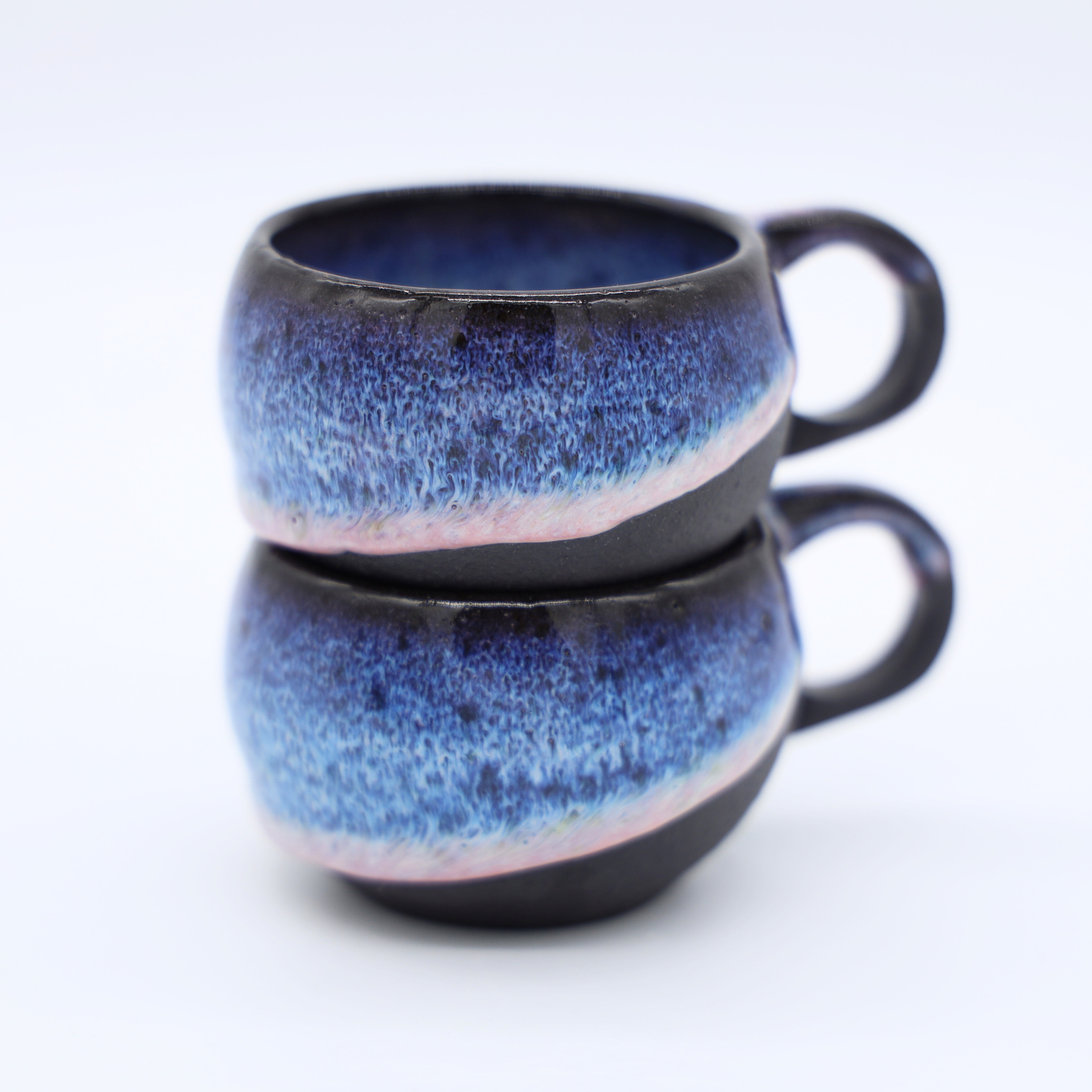 Tasses à anse en grès noir avec émail bleu glacier fabriquées artisanalement à Paris